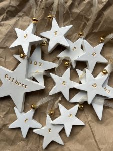White star Christmas decorations with individual initials in gold